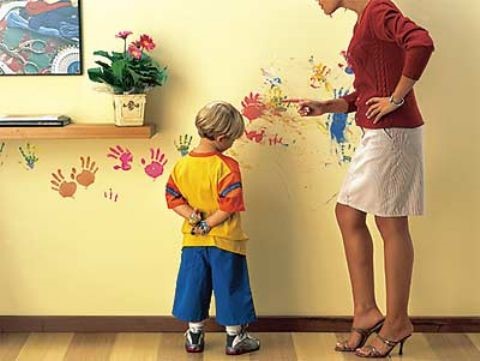 Se muestra la imagen de un niño avergonzado que ha pintado la pared de casa